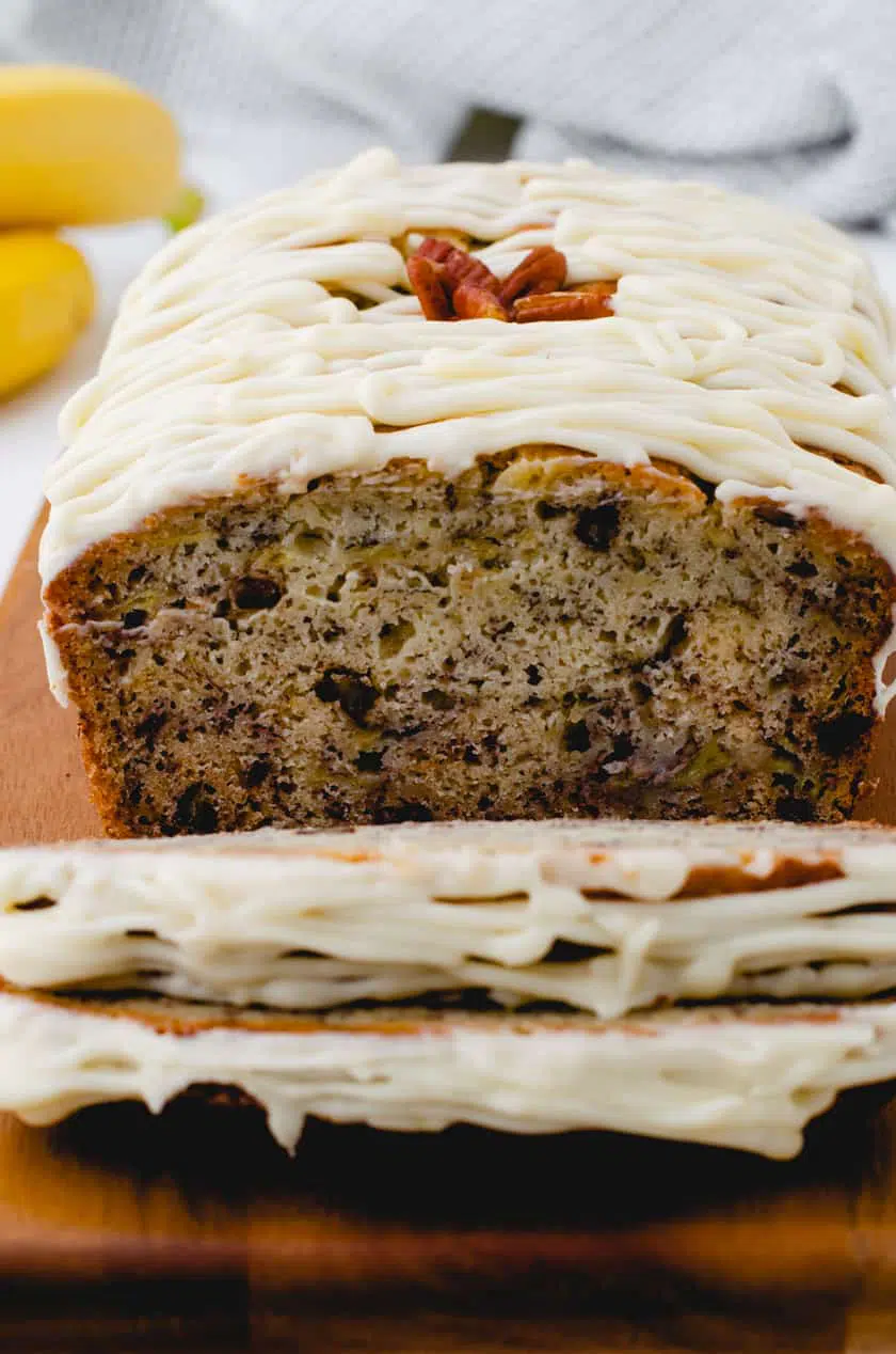 Sliced banana bread with cream cheese icing.