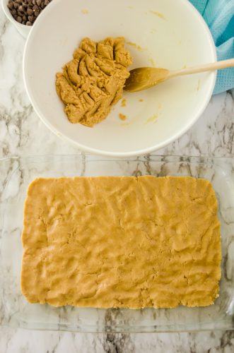 cake mix dough pressed into the bottom of a baking dish, with some reserved for topping - for peanut butter fudge bars