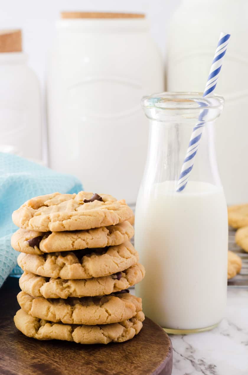 soft peanut butter chocolate chip cookies beside a glass of milk