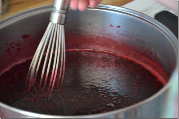 blackberry jam being beaten with a whisk