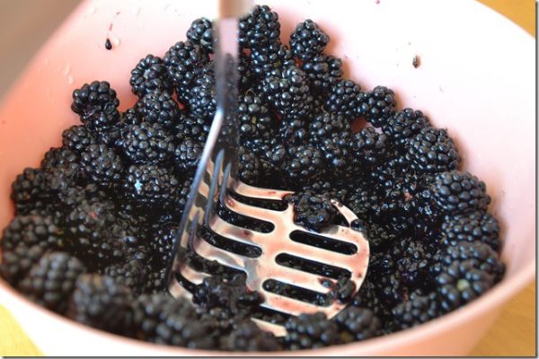 blackberries being smashed with a masher