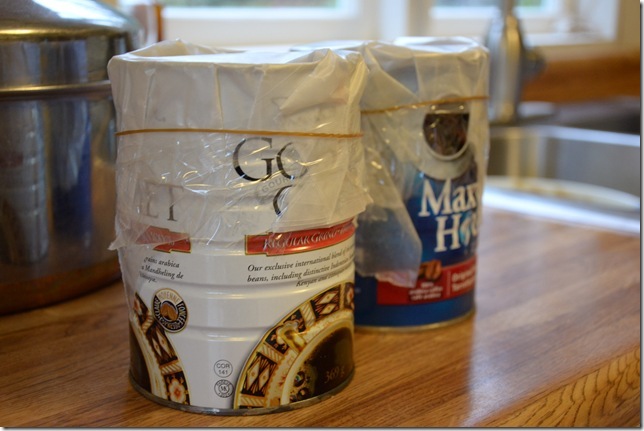 layers of wax paper taped onto cans filled with steam pudding batter with a rubber band around them