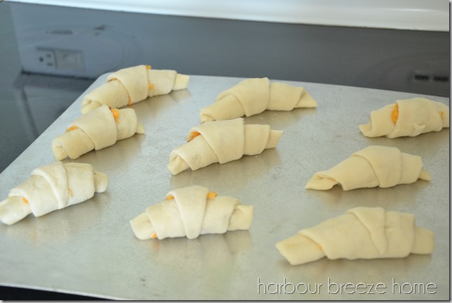Ham and cheese crescent rolls on a baking sheet.