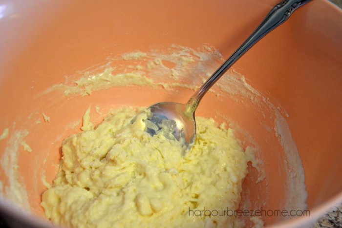 drop dumpling dough in a large bowl with a spoon