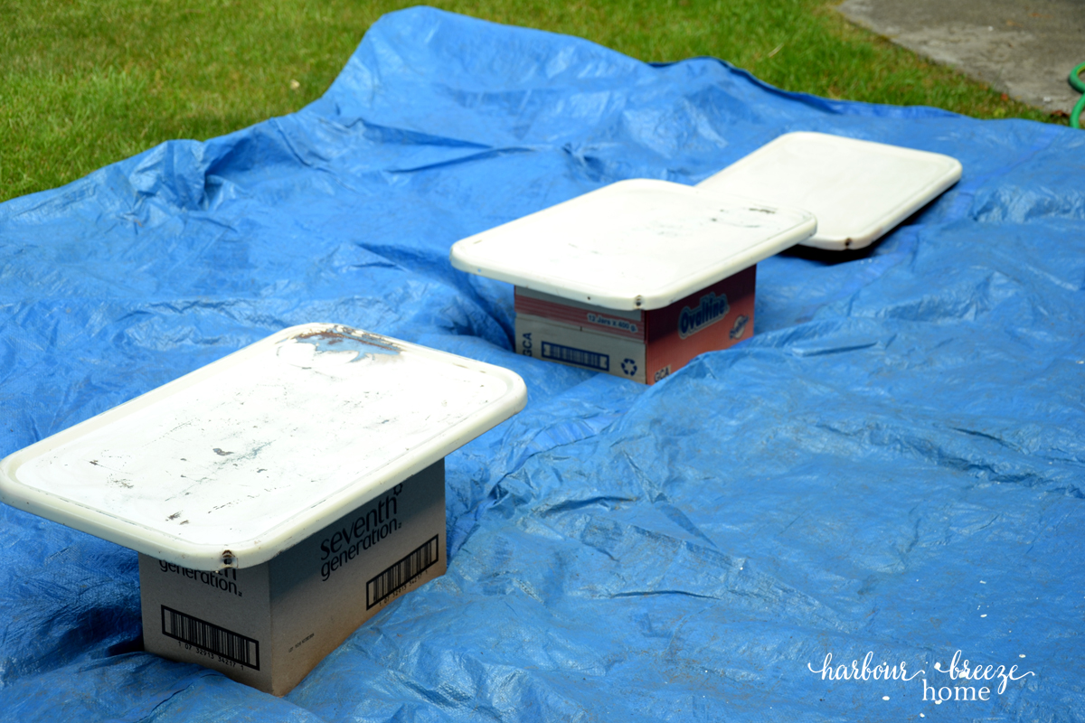 spray painting metal ~ 3 metal trays from a 3 tier rolling metal cart laid out on a tarp