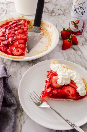 Slice of strawberry pie with whipped cream.