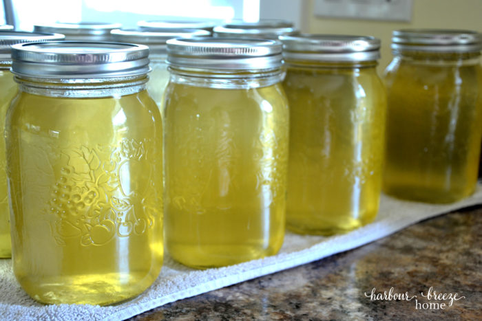 rows of apple juice in canning jars sitting on a counter