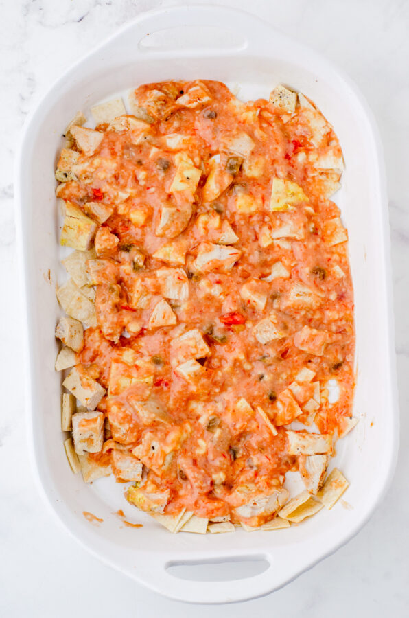 Salsa mixture poured over chicken and tortilla layers for Mexcian Chicken Casserole.