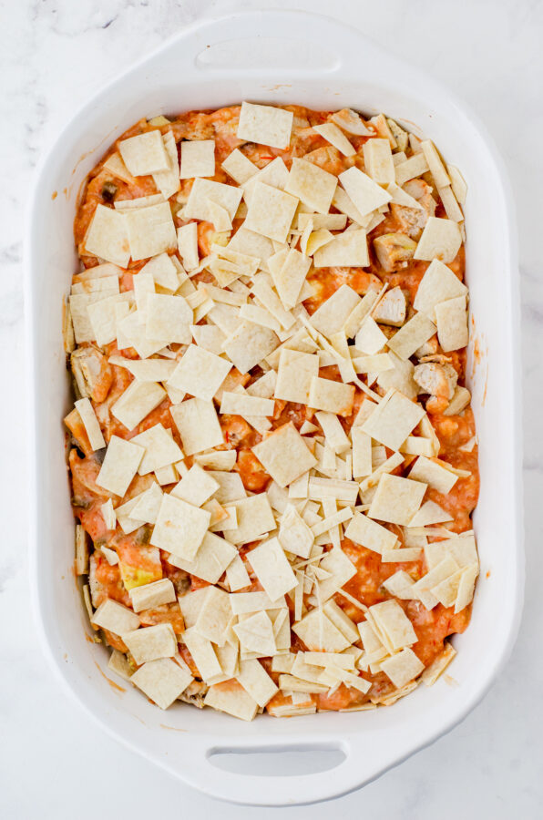 Layered Mexican Chicken Casserole with cut up tortillas on the top.