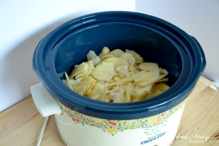 layer of potatoes and onion in a crockpot