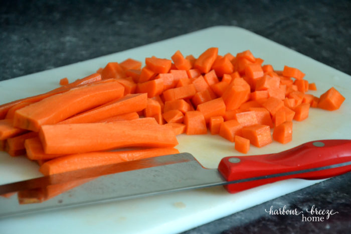 chopped carrots on a cutting board with a knife