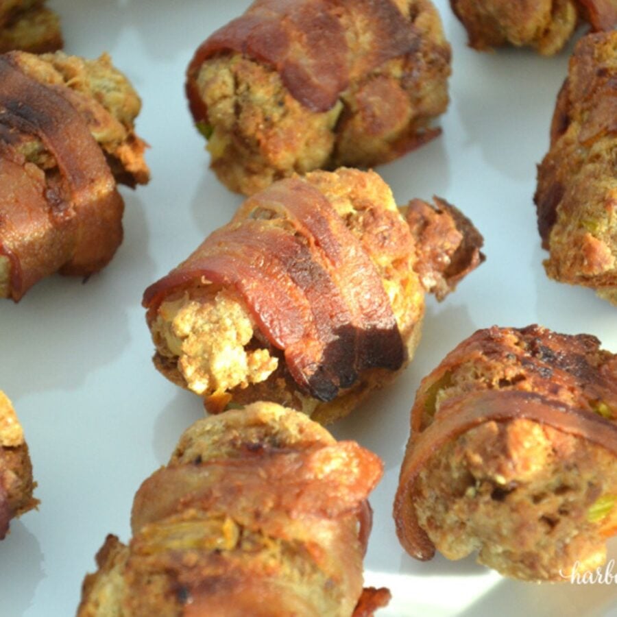 bacon wrapped stuffing balls baked on a baking sheet
