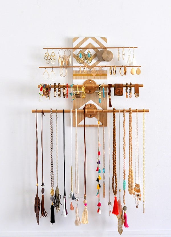 Metal rods attached to a decoratively painted board becomes a stunning art piece as it offers the practical functionality as a jewelry organizer.