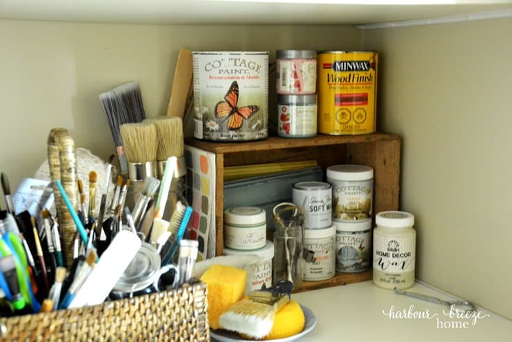 craft paints and brushes organized on a closet shelf 