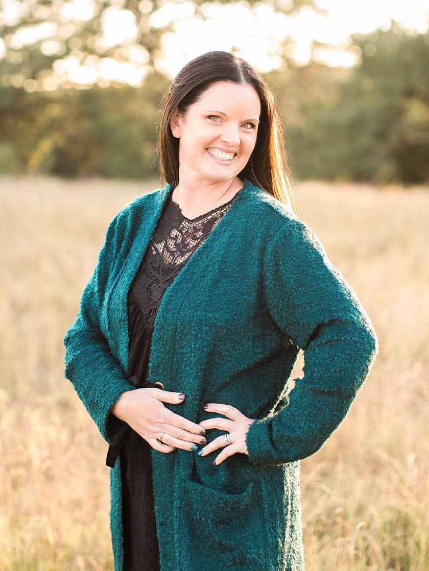 picture of smiling lady with dark hair standing in a field