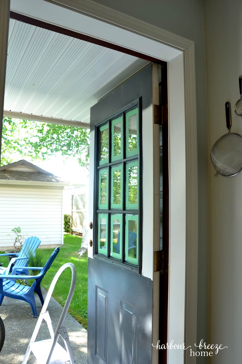 Finish painting the exterior door by rolling on the paint on the bottom half of the door and then the top. This door is painted the color Raccoon Fur by Benjamin Moore