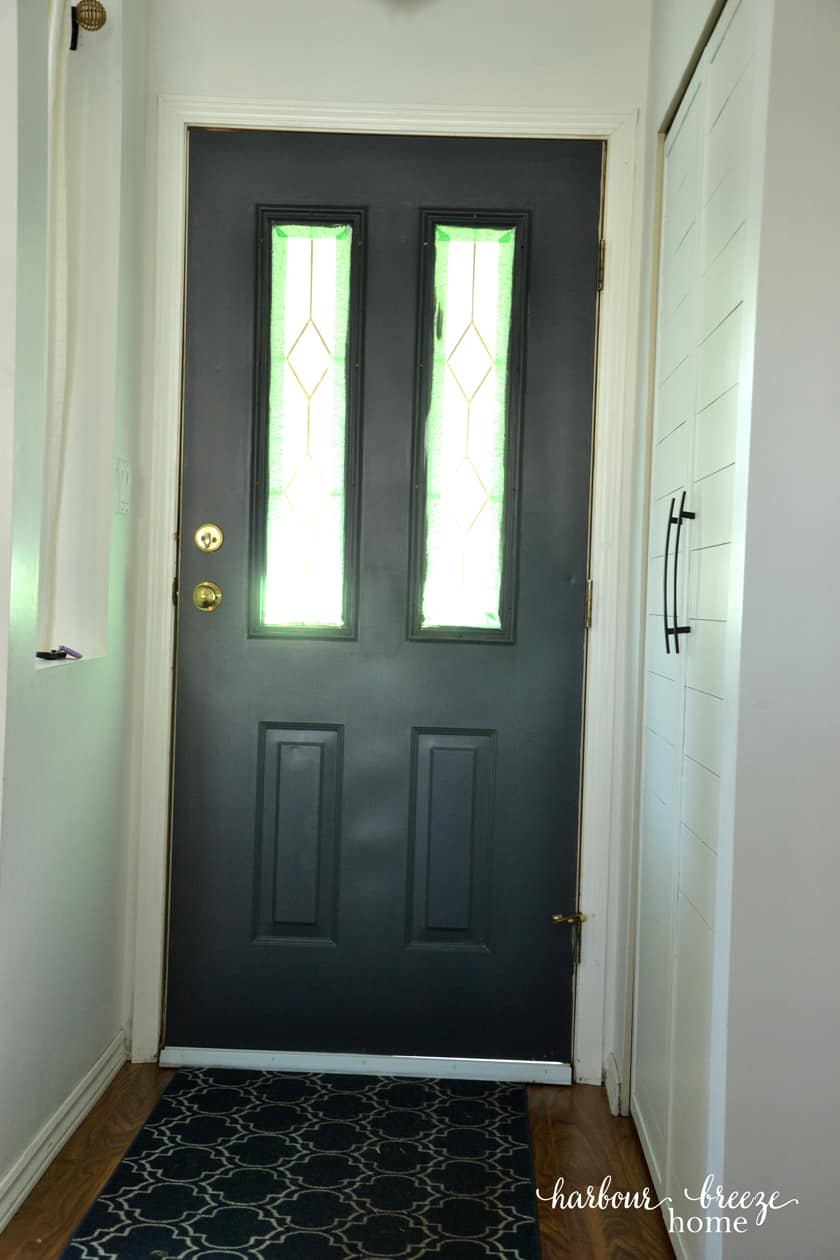 Dark gray door with white vinyl door sweep on the bottom