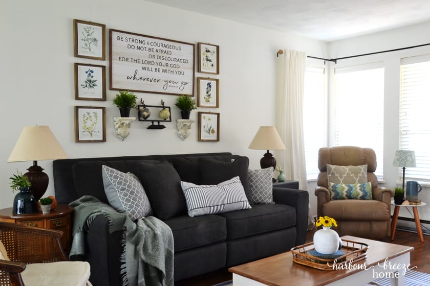 above sofa wall decor featuring a gray couch with pictures hung above it in gallery wall style