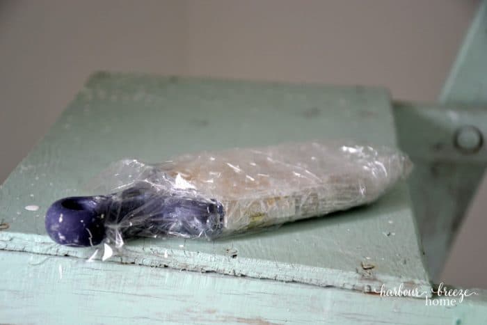 A paint brush wrapped in saran wrap