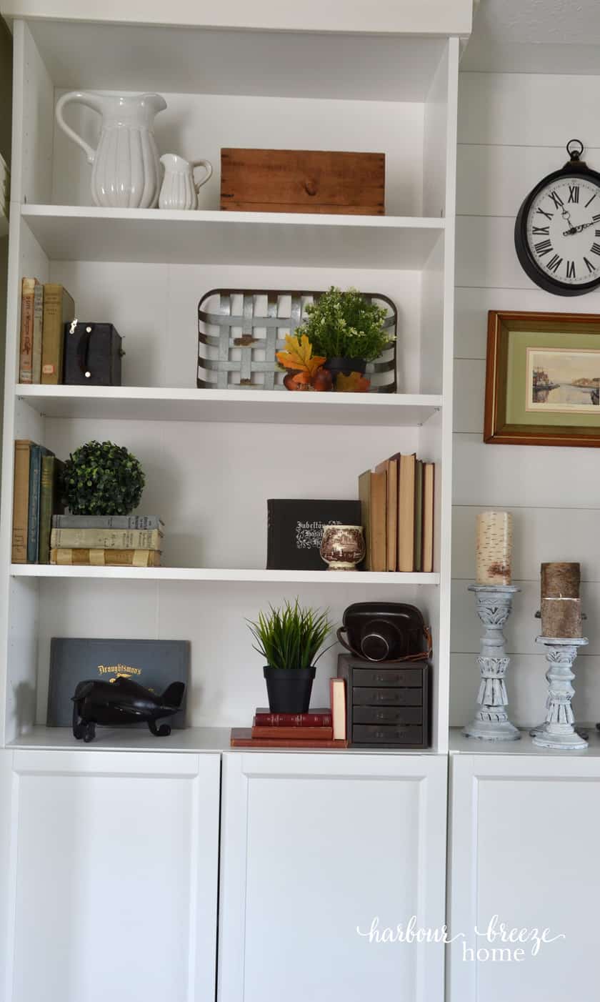 Galvanized metal tray leaning up in the back of a Billy Bookcase with a plant in front of it - a farmhouse bookshelf decor idea