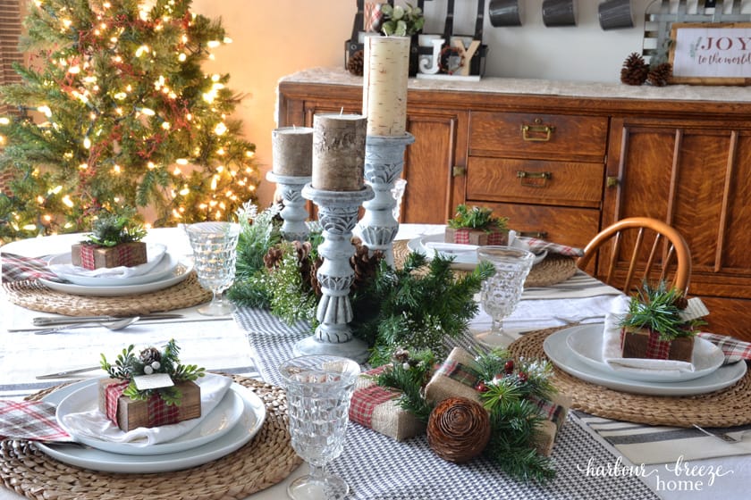 Candles and greenery down the center of a farmhouse christmas tablesetting