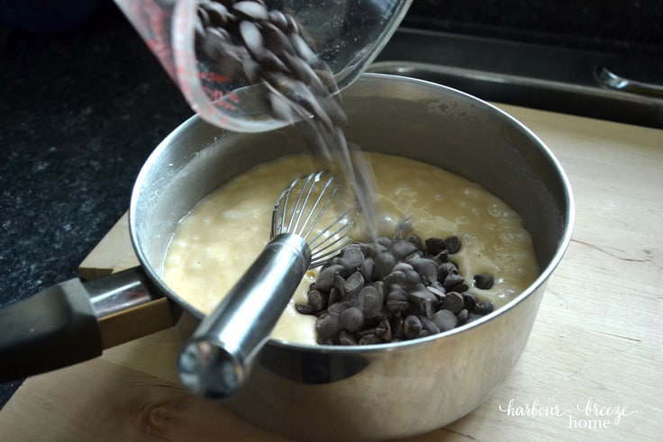 Pouring chocolate chips into chocolate fudge heated ingredients