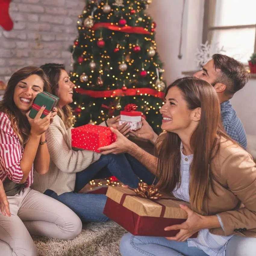 A group of people holding gifts before a gift exchange game starts.