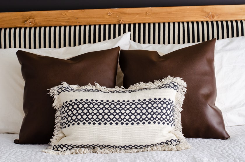 2 faux leather pillow covers on a bed