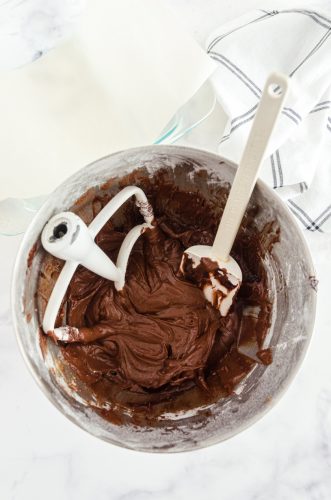 Chocolate brownie batter mixed in an electric mixer bowl.