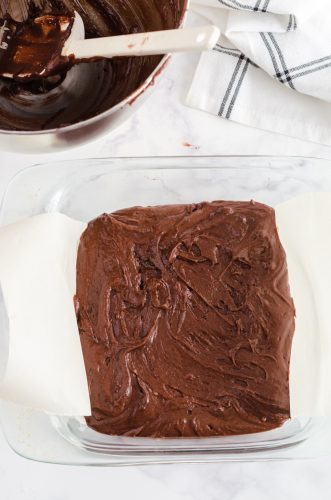 brownie batter in a parchment lined 8x8 inch baking dish.