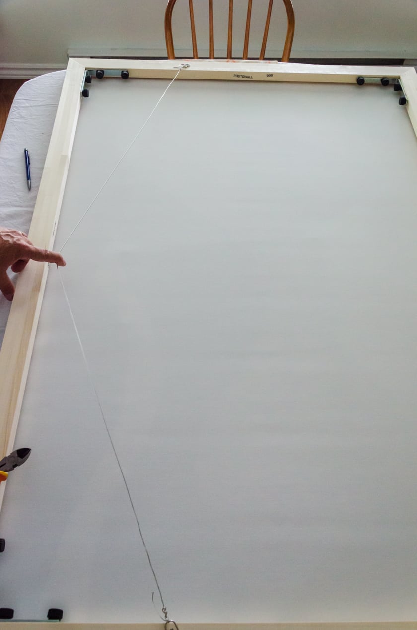 The wire hanging system on the back of a canvas with floating frame