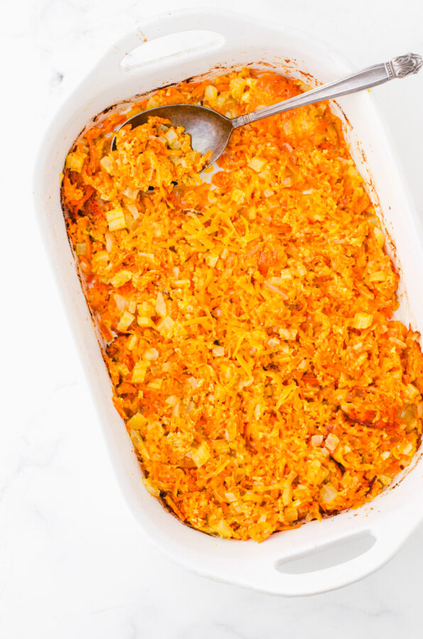 Baked cheesy shredded carrot casserole in a casserole dish.
