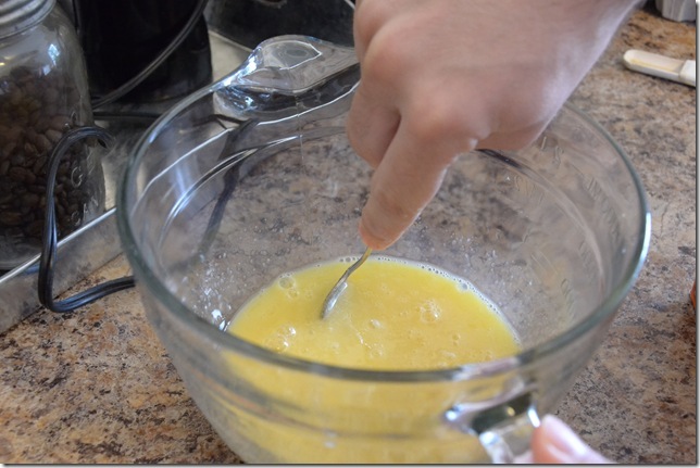 mixing liquid ingredients for rolled sugar cookies in a bowl