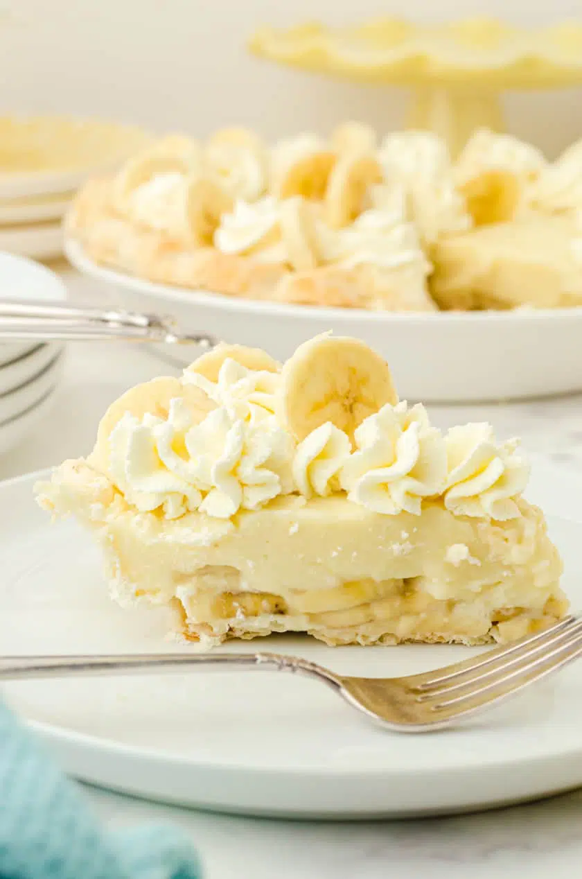 Piece of banana pudding pie on a white plate