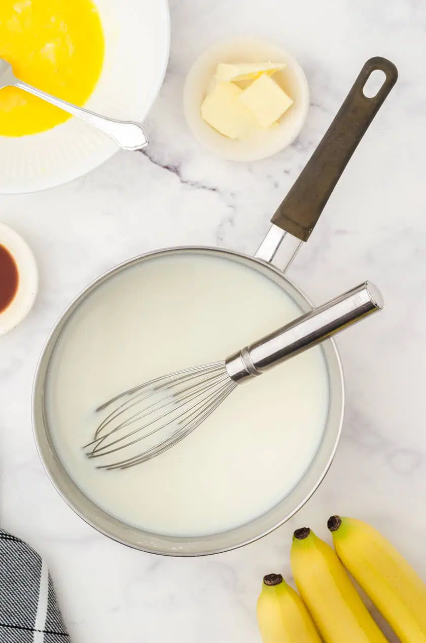 Saucepan with ingredients for vanilla pudding pie filling in it for banana cream pie.