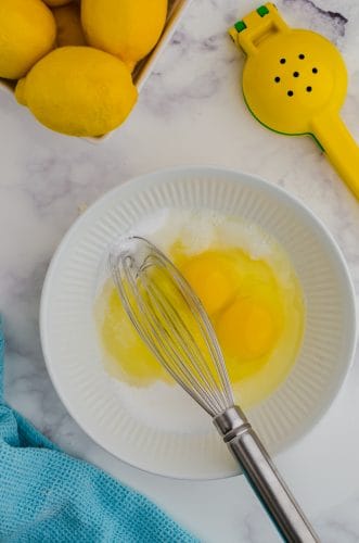 Lemon curd ingredients for lemon bars in a bowl ready to be whisked together.