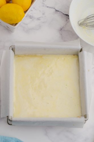 Lemon curd filling on top of shortbread crust ready to be baked.