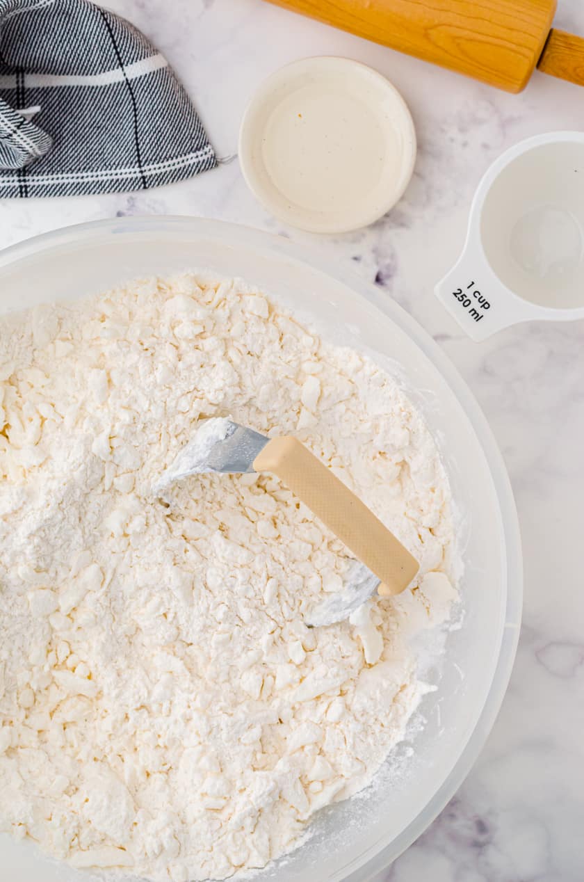 Cutting tenderflake lard into pie crust recipe with a pastry blender.