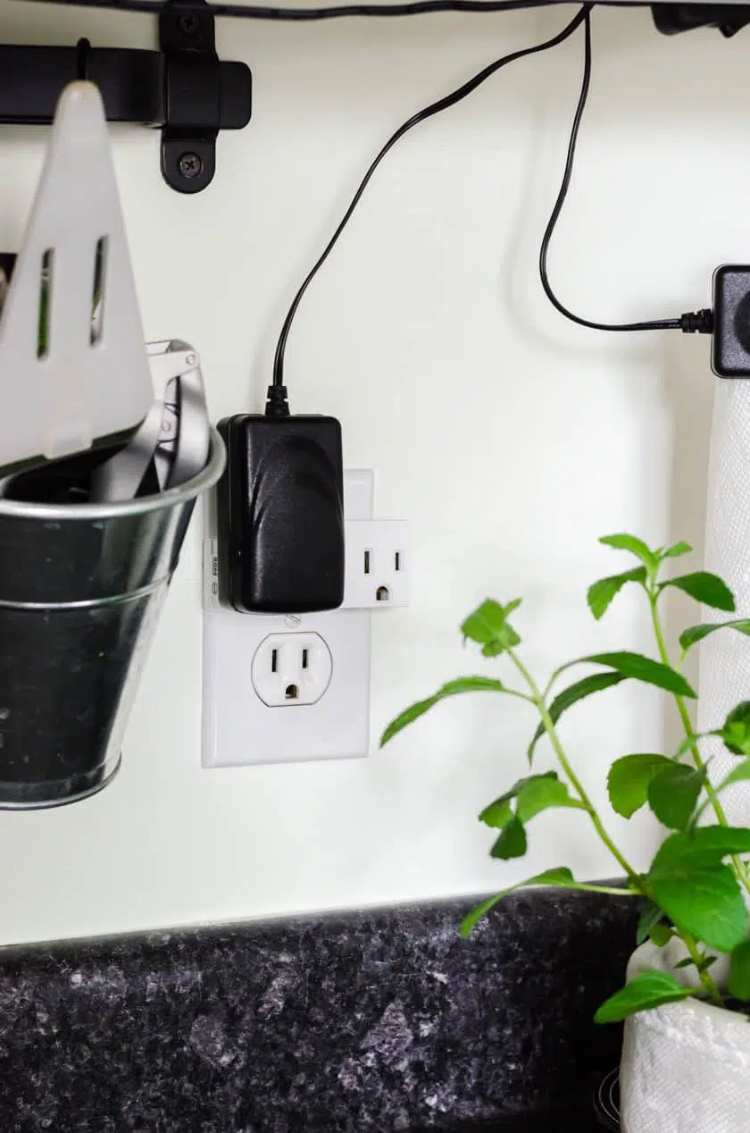 A 3 way plug in adapter plugged into the wall socket.