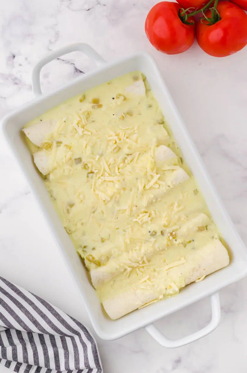 A pan of creamy chicken enchiladas assembled and ready to put in the oven.