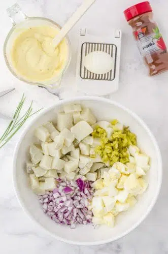Classic potato salad with egg ingredients in a mixing bowl