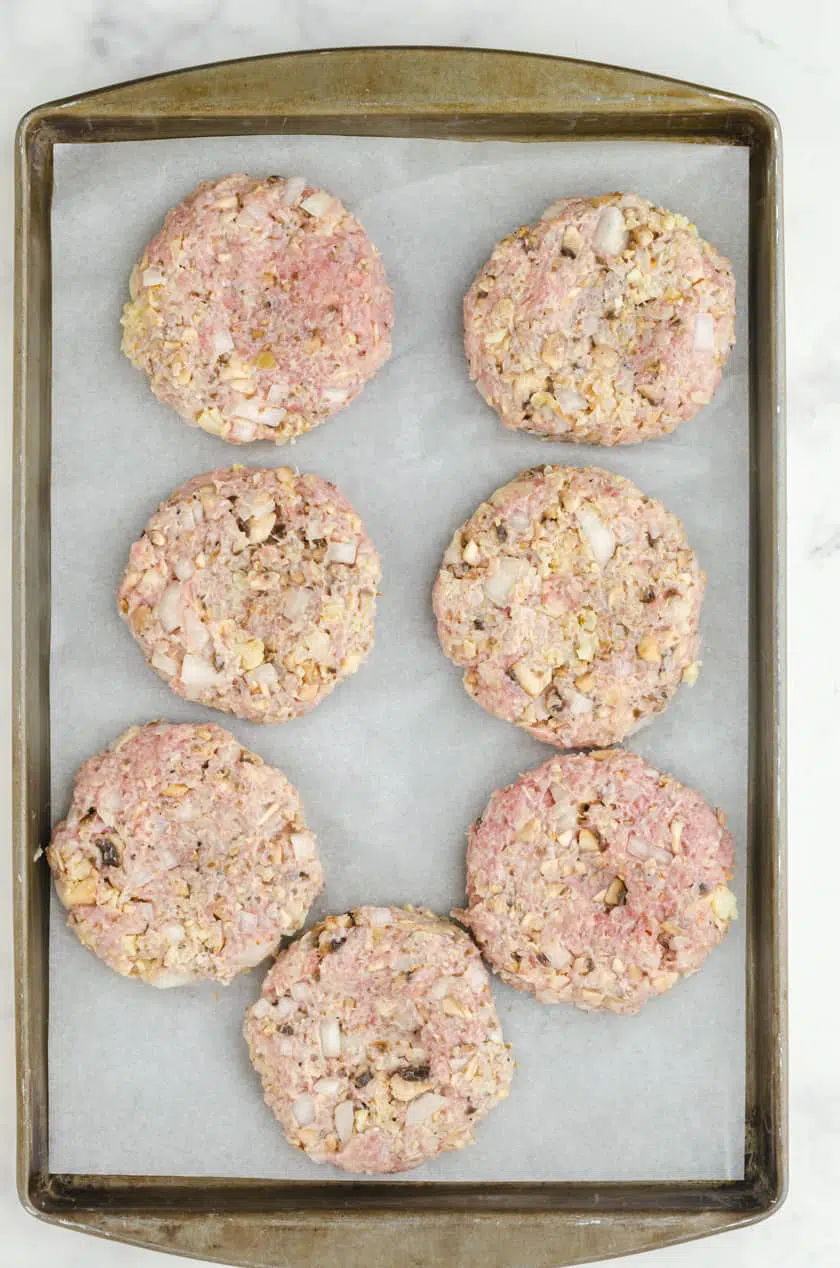 Homemade turkey burger patties on a parchment lined baking sheet