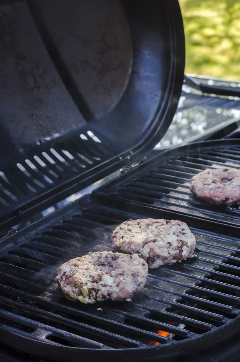 Turkey burgers cooking on a barbecue grill.