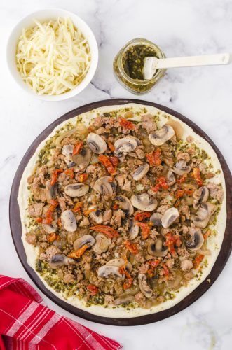 chopped sundried tomatoes layered on pesto pizza