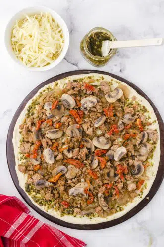 chopped sundried tomatoes layered on pesto pizza