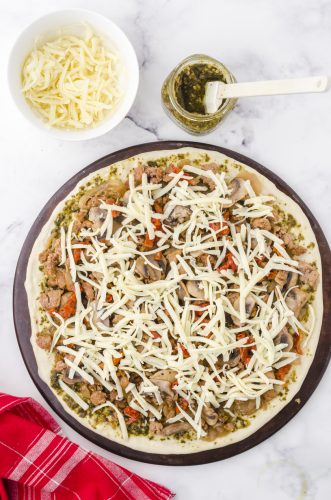 mozzerella cheese layered on a pesto pizza