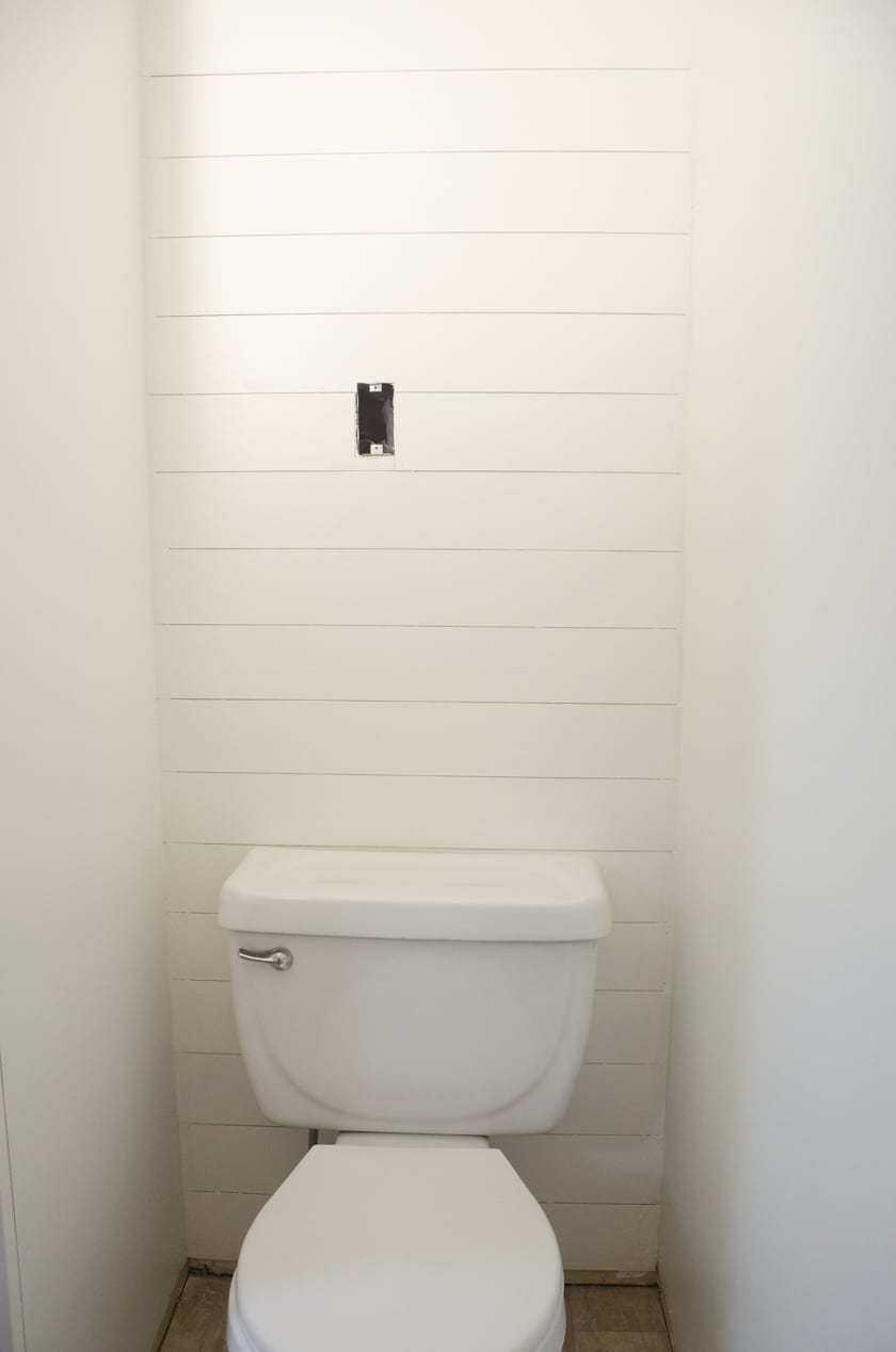 faux shiplap accent wall in a powder room behind a toilet