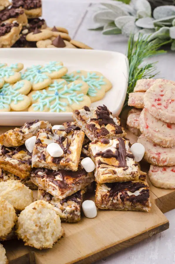 Smores magic cookie bars with marshmallows sprinkled on it as part of an arrangement on a Christmas charcuterie board.