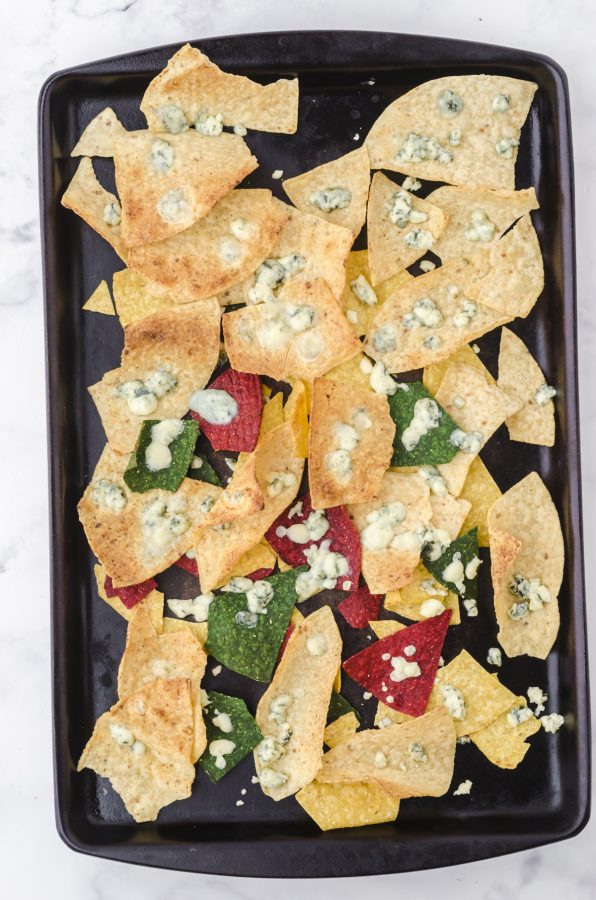A pan of oven baked tortilla chips with melted blue cheese after it has been taken out of the oven. It's the perfect sidedish to buffalo chicken chili.