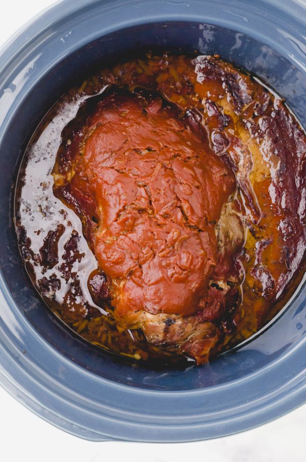 Cooked pulled pork in a crock pot ready to be shredded